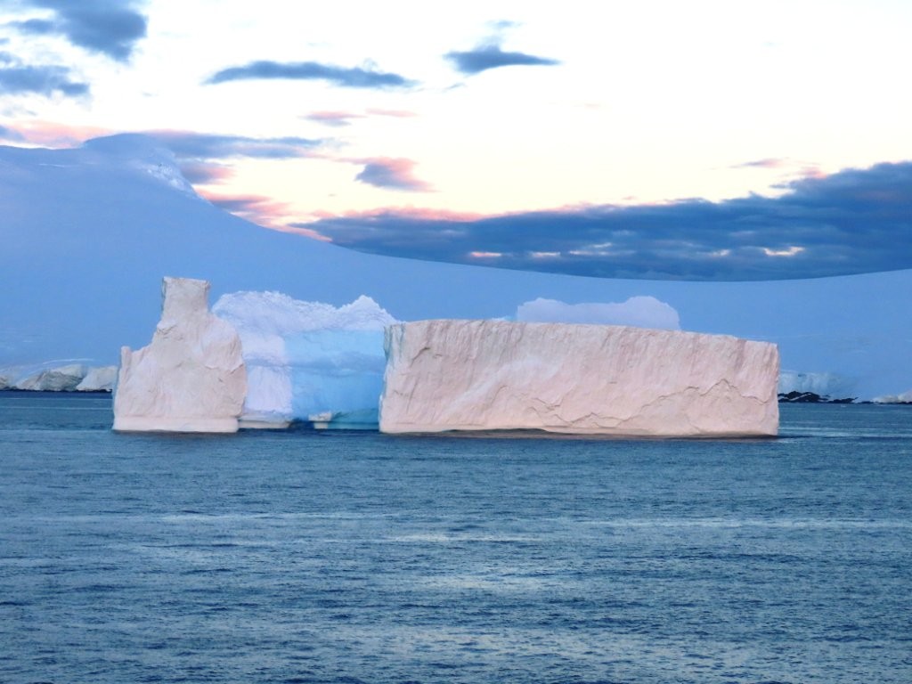 Two icebergs float past our cruise ship in the antarctic waters.