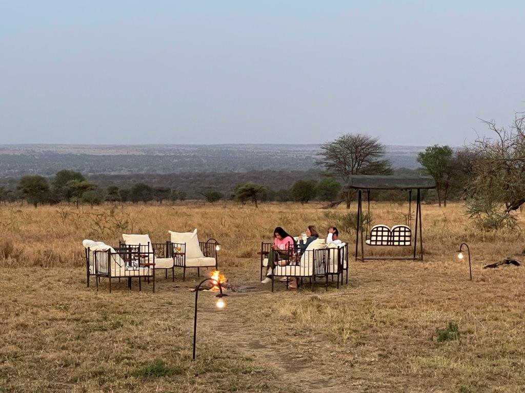 Guests sitting around the campfire discussing What’s a Tanzania Safari really like?