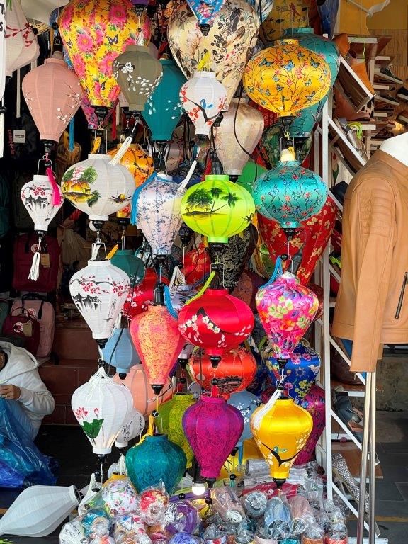 A dozen oriental themed lanterns hang for display at a storefront in Hoi An.