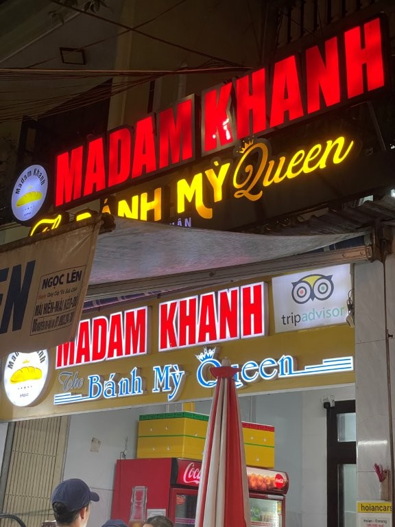 The Madam Khanh Restaurant store front with glowing neon letters.