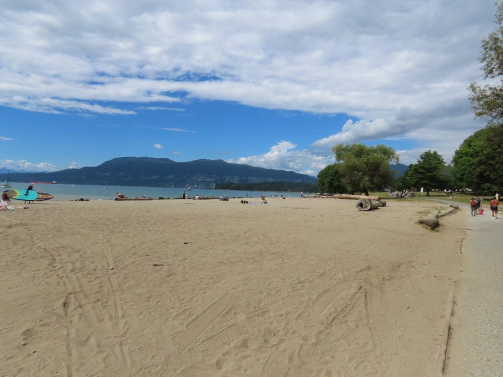 A wide expanse of brown sand fills Kitsilano Beach outside of Vancouver BC