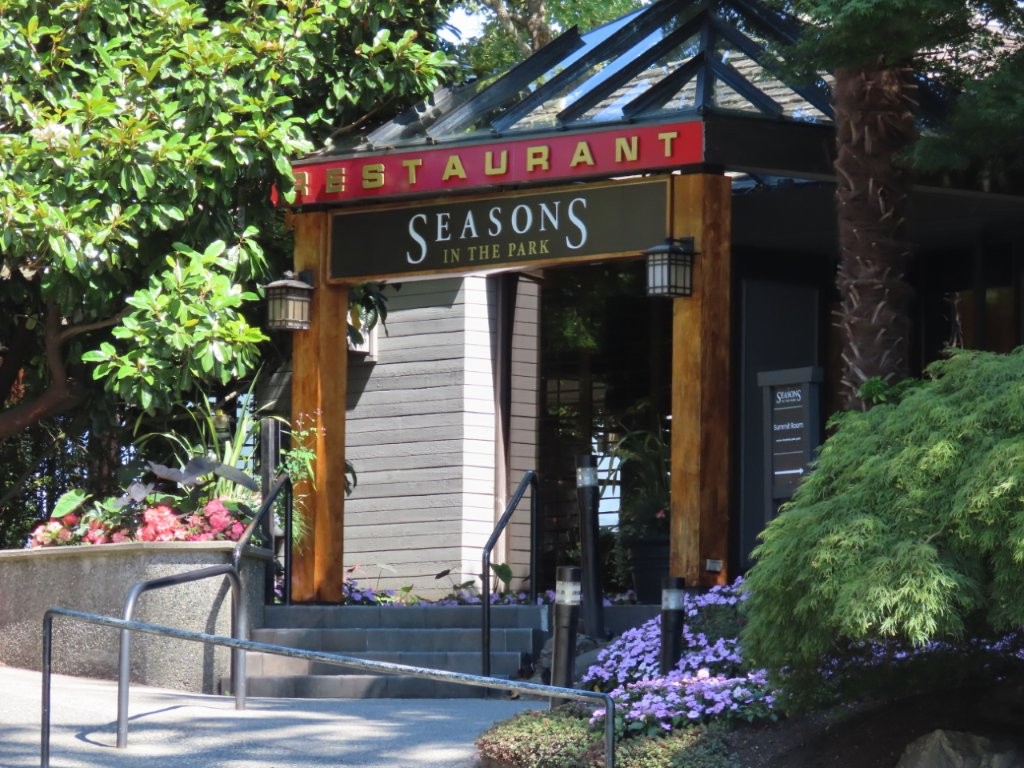 A wooden structure with signage and lanterns is the entrance that welcomes guests to the Seasons in the Park restaurant, located at Queen Elizabeth Park in Vancouver, BC