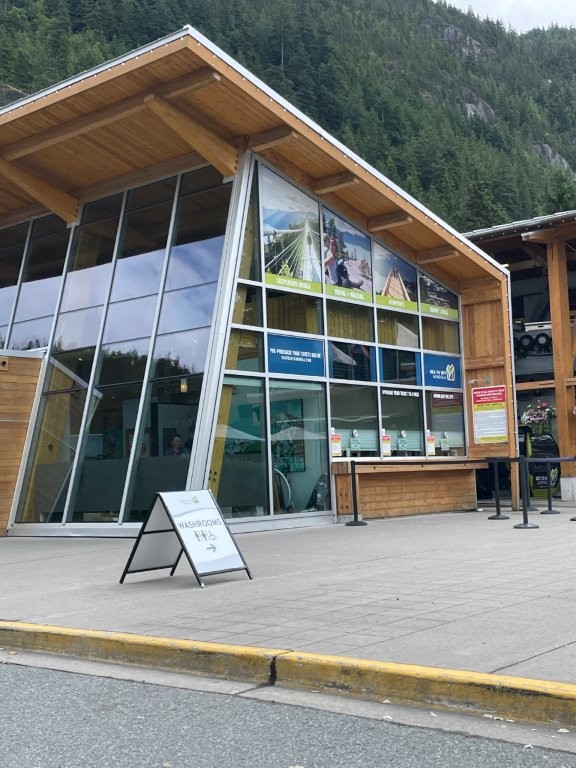 A large wooden and glass building serves as the Welcome Center for the Sea to Sky Gondola in Squamish BC.