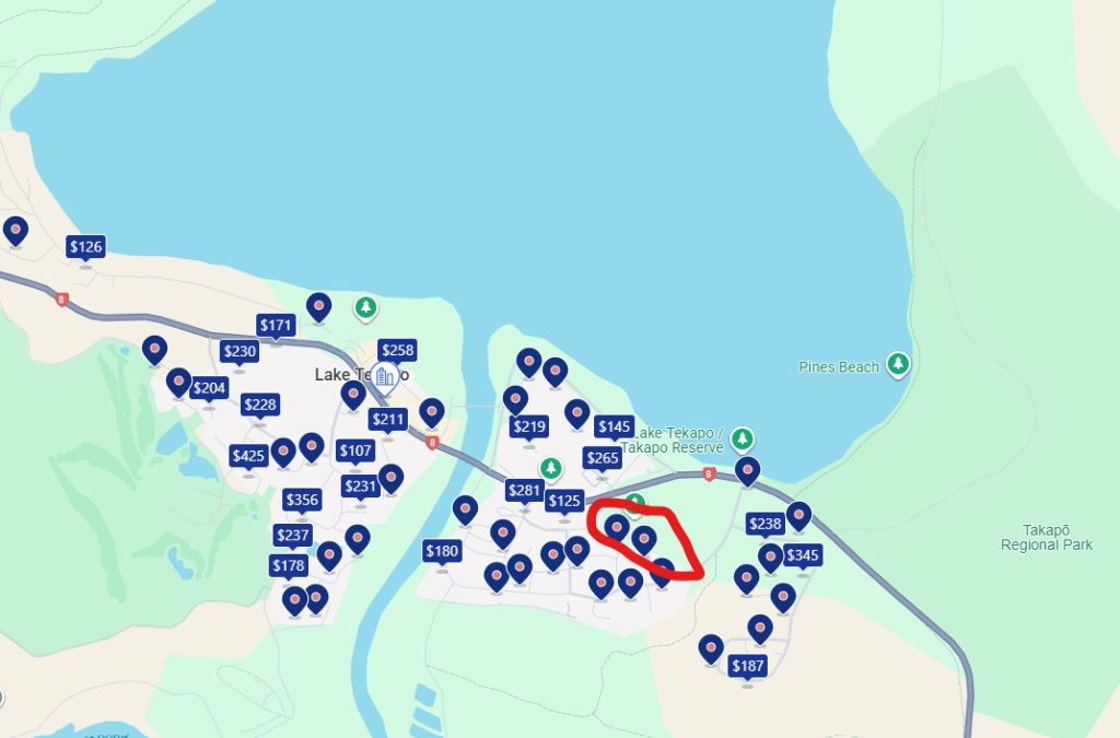 A map showing a lake and lots of blue pins which indicate rental properties available in the area.