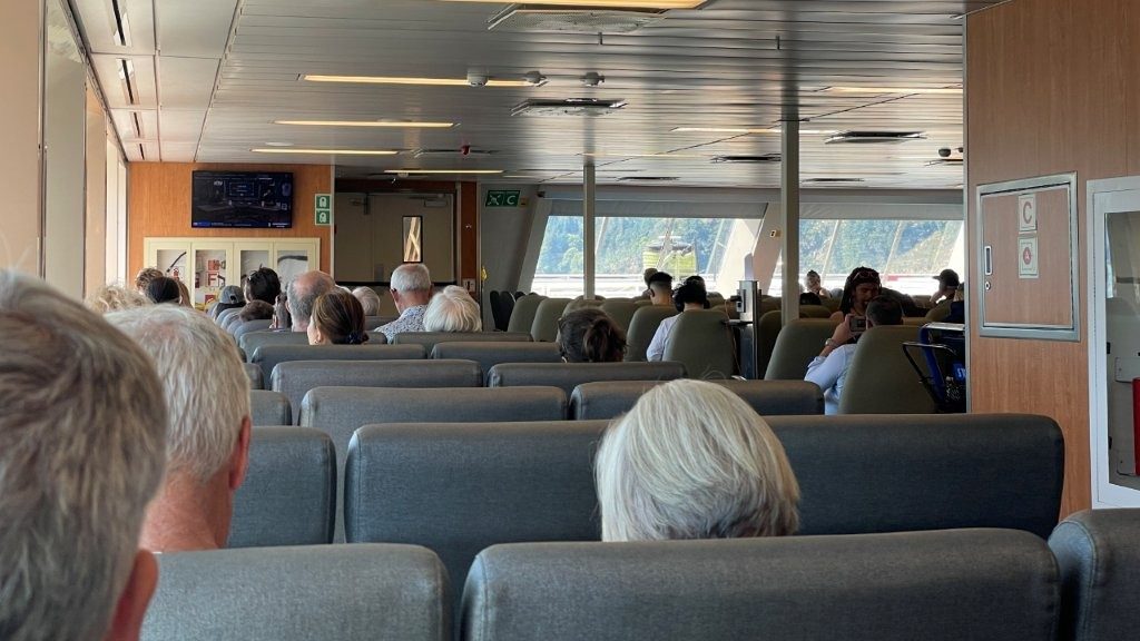 Passengers seated in the forward viewing lounge aboard the ferry with panoramic views of the water and Gulf Islands.