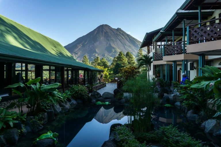 Volcano view framed by lush landscaping and reflection pond at Arenal Observatory Lodge—postcard perfect.
