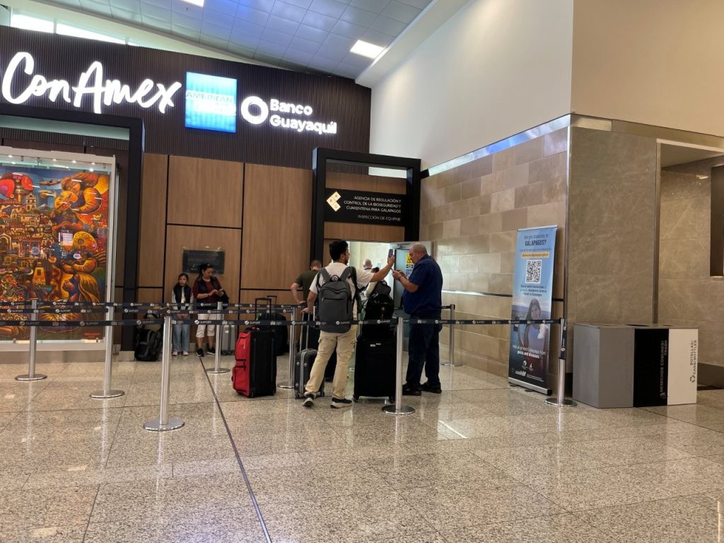 Travelers stand near the biosecurity declaration and luggage inspection area inside the Quito airport before flying to the Galapagos. This is where the airport process can feel confusing if you have not completed the declaration in advance.