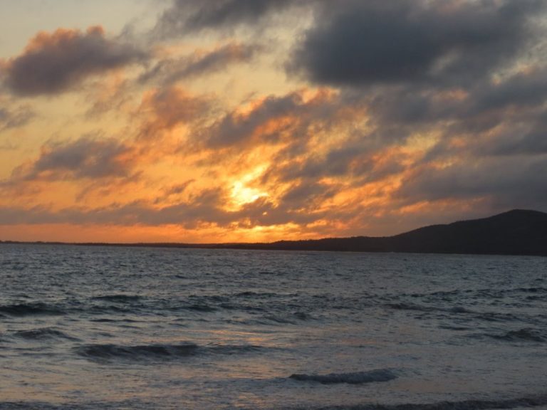 The sun sets behind dark clouds over the ocean near Puerto Villamil on Isabela Island. Evenings on Isabela Galapagos felt slower, quieter, and more relaxed than anywhere else we visited.