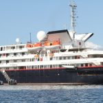 The Silversea Explorer Galapagos liveaboard floats on calm blue water with multiple decks, lifeboats, and expedition gear visible. Seeing the ship helps readers picture the cruise-style option when comparing a Galapagos liveaboard vs land-based trip.