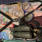 A suitcase is packed with a snorkel mask, binoculars, sunscreen, pink packing cubes and other colorful items. Knowing what to pack for the Galapagos is a key part of a successful trip.