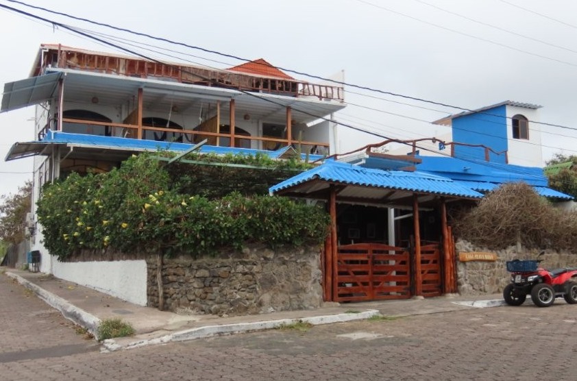 A multi-level boutique hotel with blue roofing and wood balconies sits on a quiet corner near Playa Mann on San Cristobal Island. Visiting Galápagos Casa Playa Mann in person helped me evaluate one of the best boutique options for where to stay in San Cristobal.