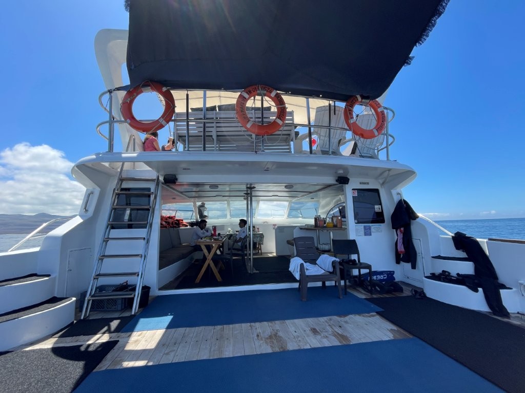 A spacious catamaran floats on bright blue water during our Kicker Rock snorkeling tour from San Cristobal. Boat comfort made a big difference on this full-day Galapagos snorkeling trip.