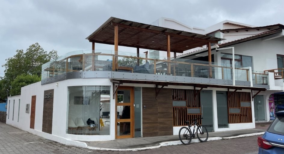 A modern white corner hotel with a glass-railed rooftop terrace and wood accents sits on a quiet street in Puerto Ayora. Hotel Acacia is a strong mid-range choice for where to stay in Santa Cruz Galapagos if you want upgraded amenities without full luxury pricing.