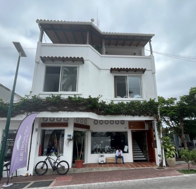 Hotel Cucuve’s white exterior rises above street-level shops with rooftop terraces and vines softening the front of the building. This boutique hotel gives travelers a central Puerto Ayora base with a quieter, smaller-property feel.