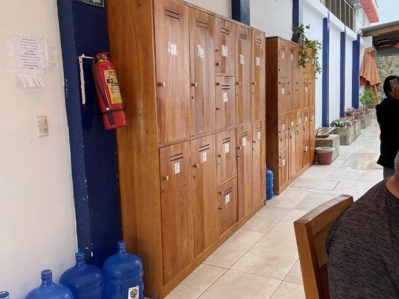 Tall wooden luggage lockers line a narrow indoor storage area near the Santa Cruz ferry dock. Storing bags during a long Puerto Ayora layover makes it much easier to explore town between Galapagos ferry rides.
