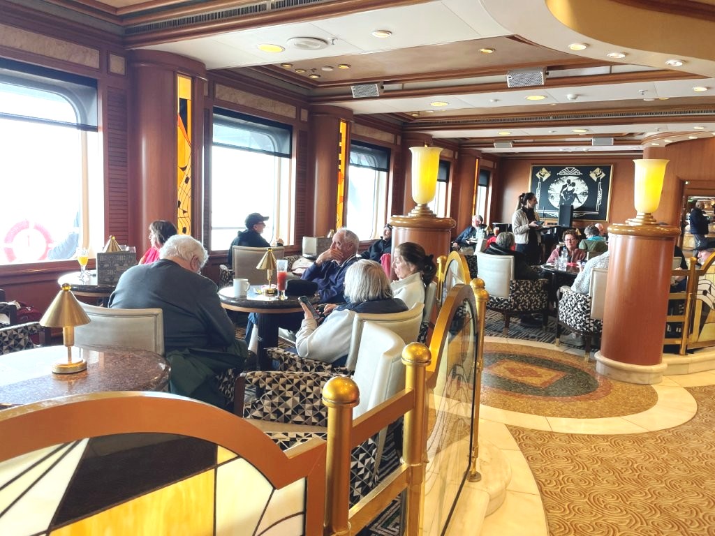 Curved seating surrounds the piano bar with warm wood finishes, tables, and soft lighting. 