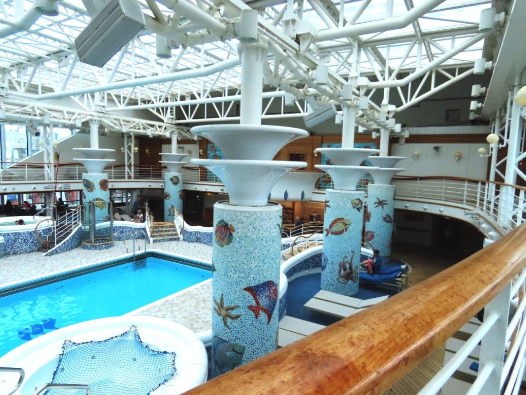 The covered indoor pool is surrounded by lounge chairs beneath a glass roof that lets in natural light. This area stays comfortable even when the weather outside isn't ideal.