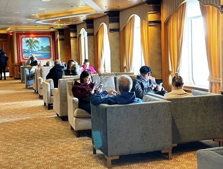 Curved armchairs and small tables create a comfortable seating area beside floor-to-ceiling windows. These public lounges were rarely crowded and were great places to watch the scenery.
