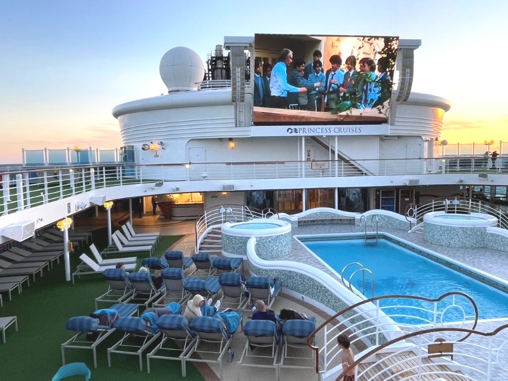 Lounge chairs surround the outdoor pool beneath the large Movies Under the Stars screen. This is one of the busiest gathering places on warm-weather sailings.