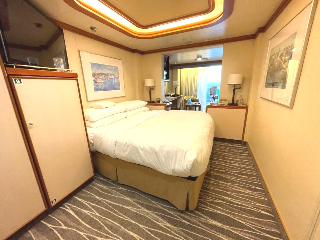 The two twin beds have been pushed together to create one larger bed, with bedside tables and lamps against the back wall. Princess did not officially arrange the beds this way, but we moved them ourselves after boarding.