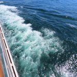 Gentle waves roll past the side of a cruise ship, leaving a ribbon of turquoise wake behind. The photo illustrates the relatively calm conditions we experienced while crossing the Drake Passage.