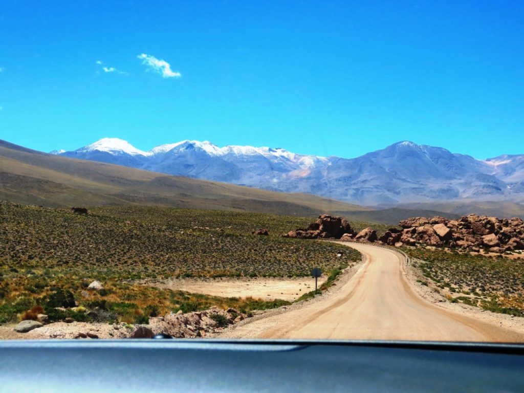 A steep gravel road drops across a bare mountainside toward the vast desert basin far below. The long descent made us realize how high we had climbed and how much the altitude had drained our energy.