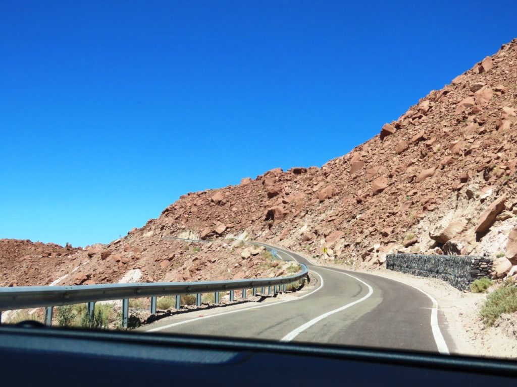 A paved road curves through the steep cliffs on both sides. It required careful focus to drive this stretch of B-207 in Northern Chile. 