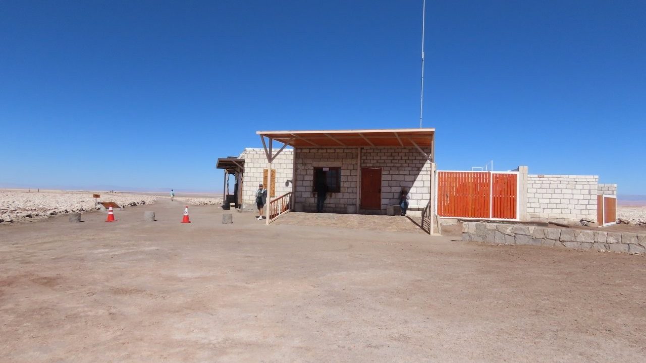 A small stone visitor center stands alone on the flat desert beneath a deep blue sky. We checked in here with the online QR codes before walking out toward the lagoons.