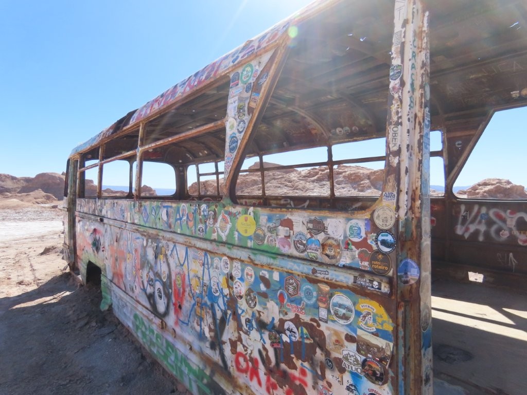 Looking through the missing windows of the old Magic Bus frames the surrounding desert landscape. It has become one of the Atacama's most unusual roadside photo stops.