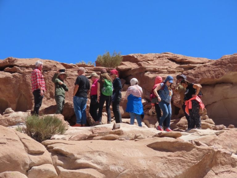 A tour group stands on the rocks, listening to their guide. Exploring Yerbas Buenas involved more climbing and scrambling than I expected.