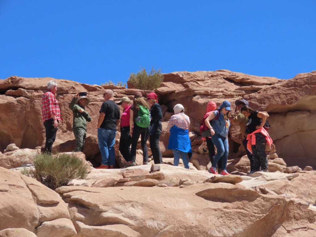 A tour group stands on the rocks, listening to their guide. Exploring Yerbas Buenas involved more climbing and scrambling than I expected.