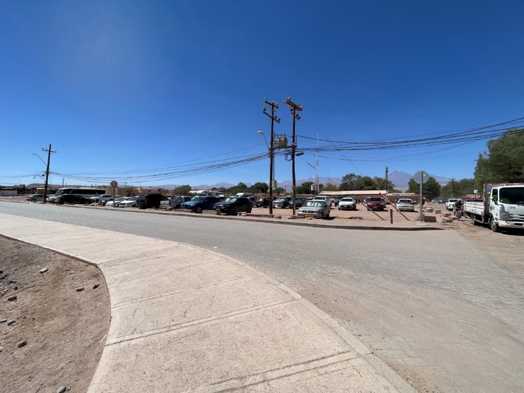 A large parking area near downtown San Pedro de Atacama offers views of a volcano rising in the distance. Finding convenient parking can make exploring the town center much easier for self-drive travelers.