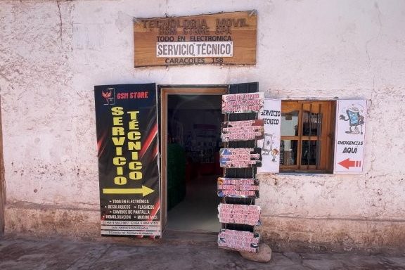 An adobe-style storefront houses a small electronics shop and postal service counter in San Pedro de Atacama. Knowing where to find essential services can be helpful during an extended stay in the Atacama Desert.