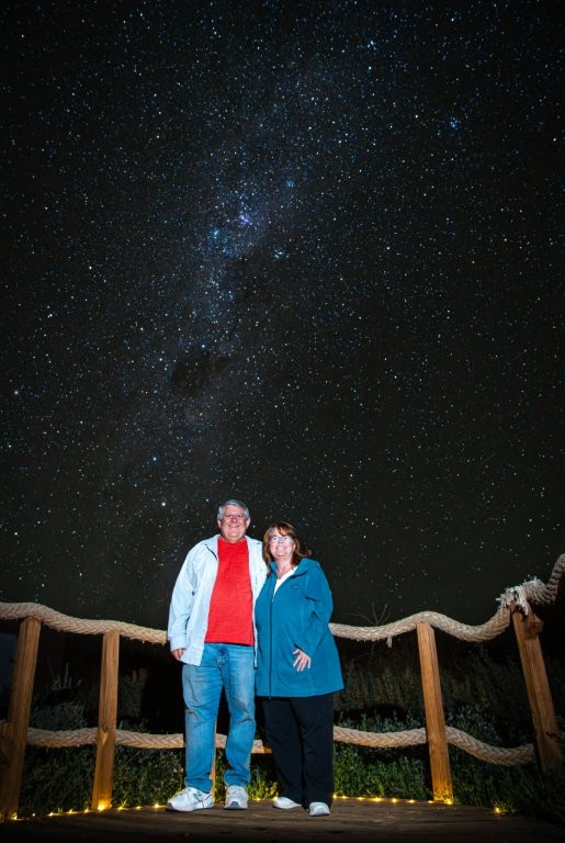 Bill and Kari stand beneath the Milky Way after our guided stargazing experience in the Atacama Desert. Guided tours often include professional night-sky photos to remember the experience.