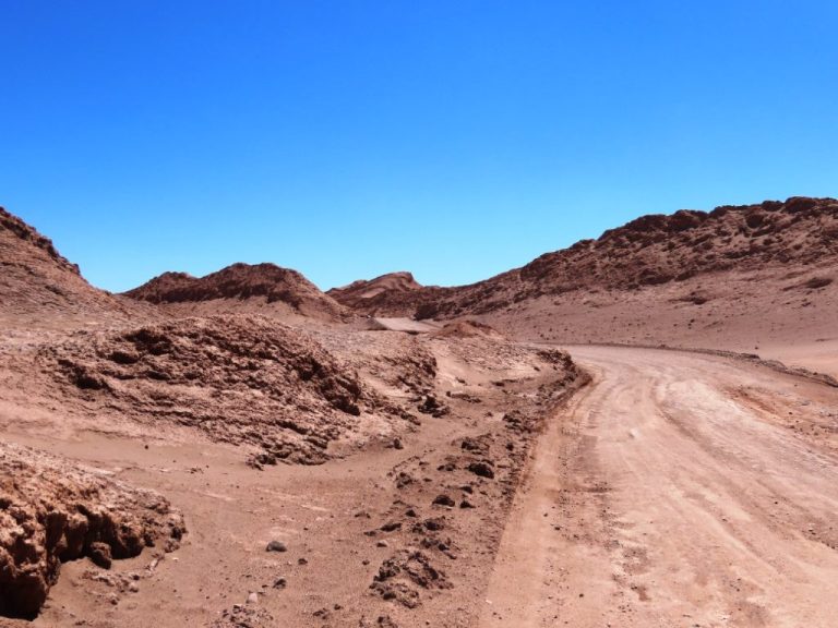 The road winds through colorful desert ridges inside Valle de la Luna. This view gives a sense of what you'll experience during the self-drive route.
