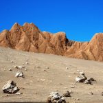 Layers of weathered rock and distant volcanoes create the dramatic scenery inside Valle de la Luna. Exploring by car makes it easy to stop at viewpoints throughout the park.