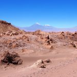 Panoramic view of the rugged rock formations and winding road through Valle de la Luna in Chile's Atacama Desert. This landscape introduces one of the region's most popular self-drive adventures.