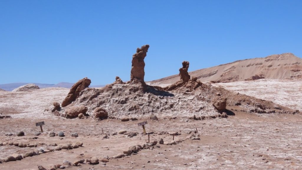 Three dark piles of rocks stand on raised ground. These so-called Statues represent the Three Marys.