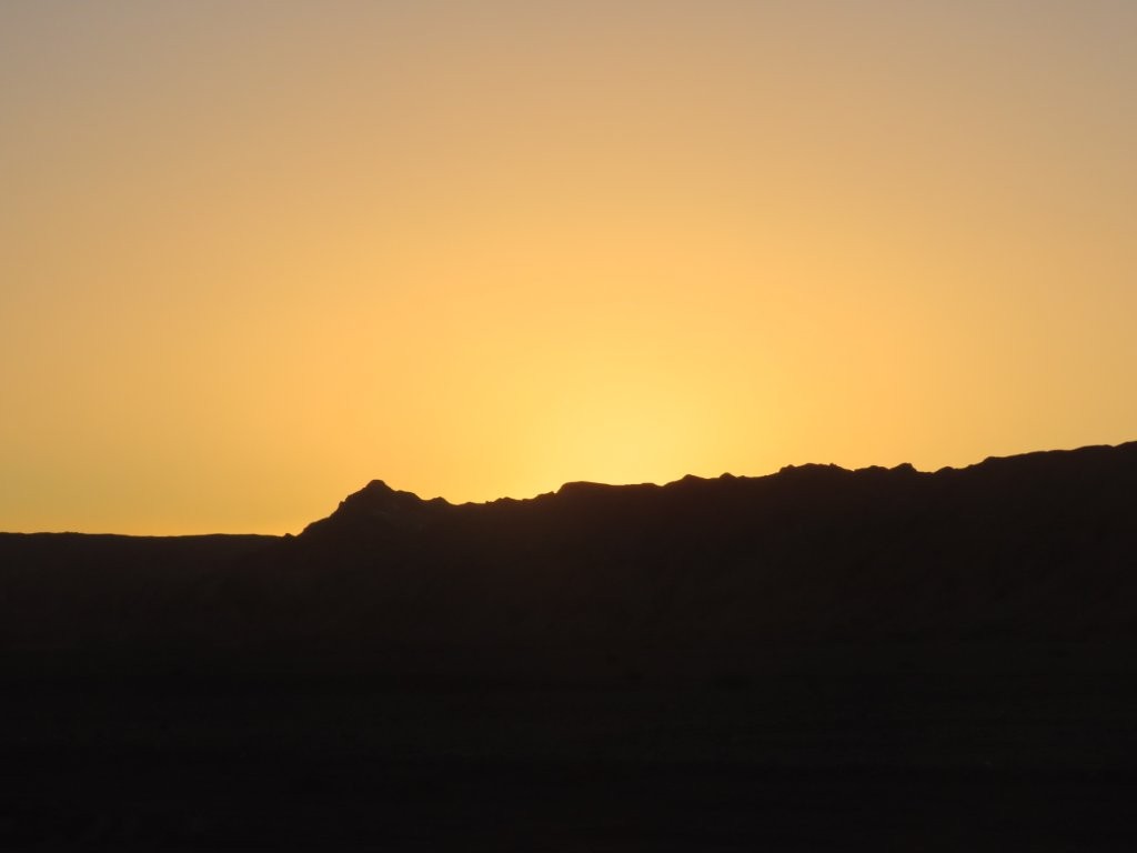 Golden evening light stretches across the Atacama Desert as the sun begins to set beyond the mountains. Ending the day here is a memorable finale to this self-drive route.