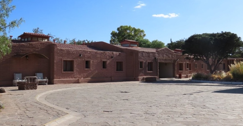 Adobe-style guest buildings line a spacious stone courtyard beneath clear blue skies at La Casa de Don Tomás. This is the kind of property I’d look at if I wanted a dependable hotel with more space to spread out.