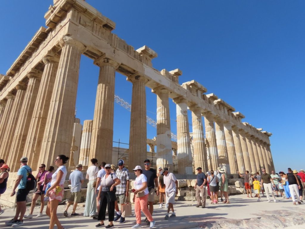 Parthenon rises against a brilliant blue sky above visitors exploring the Acropolis in Athens, Greece. This iconic view introduces an Athens itinerary 2 days before or after a cruise with the city’s one attraction I wouldn’t miss.