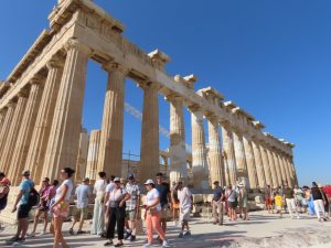 Parthenon rises against a brilliant blue sky above visitors exploring the Acropolis in Athens, Greece. This iconic view introduces an Athens itinerary 2 days before or after a cruise with the city’s one attraction I wouldn’t miss.