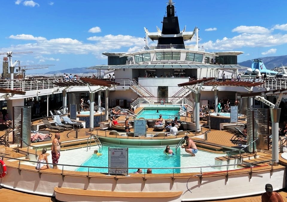 Celebrity Infinity’s outdoor pool sits beneath a bright blue sky with passengers swimming and relaxing on surrounding lounge chairs. The pool deck was one of the livelier areas aboard the Celebrity Infinity cruise ship, especially during sea days.